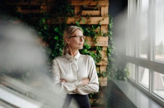 Corporate Social Responsibility, eine Frau schaut aus dem Fenster