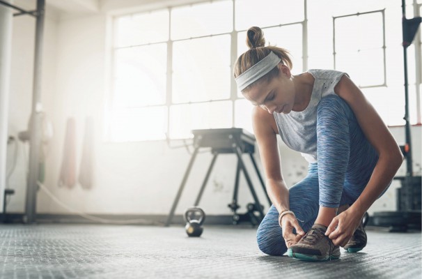 An athlete is tieing her shoe.