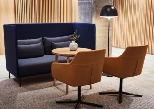 A seating area with a contemporarily designed couch, two armchairs and a floor lamp.