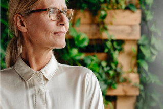 Portrait of an employee in front of a greenery wall.